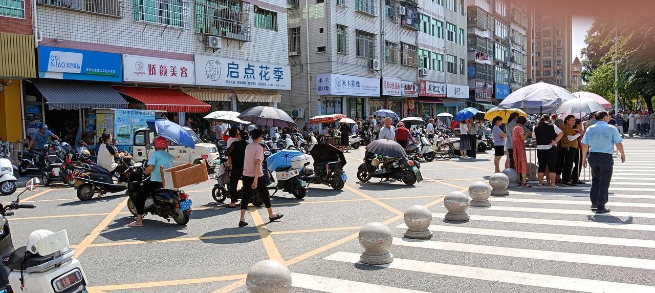 中午十一点，长泰区第二实验小学文昌校区，接小孩回家吃饭的家长冒着炎热的阳光，早早