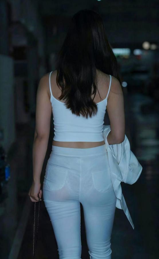 深夜车库，淡蓝灯光裹着她的白衫白裤，光影里泛着柔。外套与链条包轻晃，在寂静里敲着