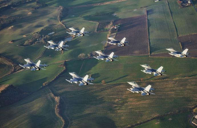图中展示的是F-16“战隼”战机编队飞越农田上空。F-16是由美国通用动力（后由