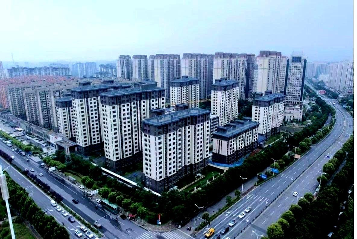 钥匙一串串往手心落下时，绿洲花园门口像过年。
红条幅拉到街口，合同上的红章还在冒