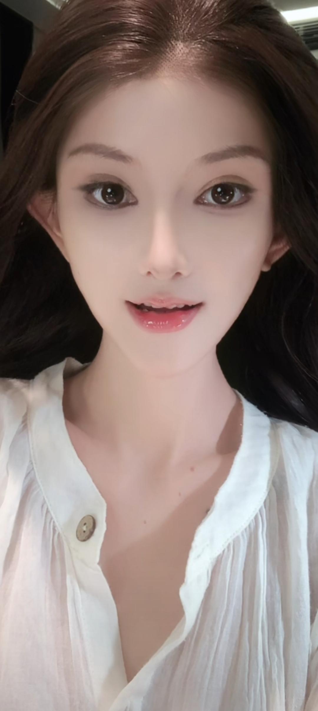 这位美女穿着白衬衫，看着镜头。