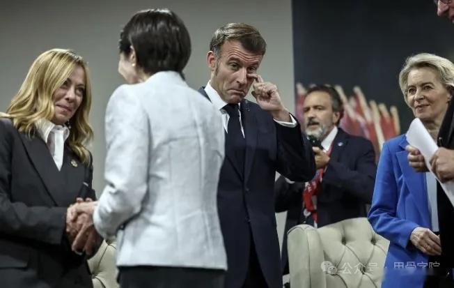 法国的总统两个手都很忙，一个藏在后面，一个在忙着揉眼睛 