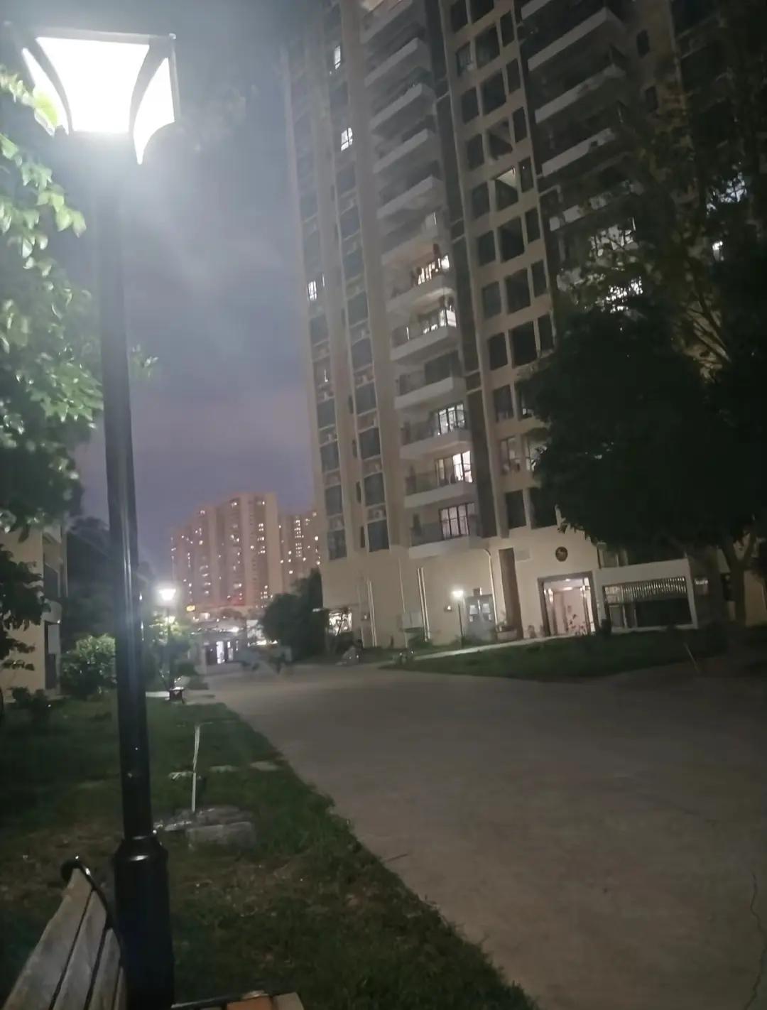 路灯轻吻夜色，楼宇静默如诗，风穿过树影低语。夜晚的小区一角，把音量调到最大，听城