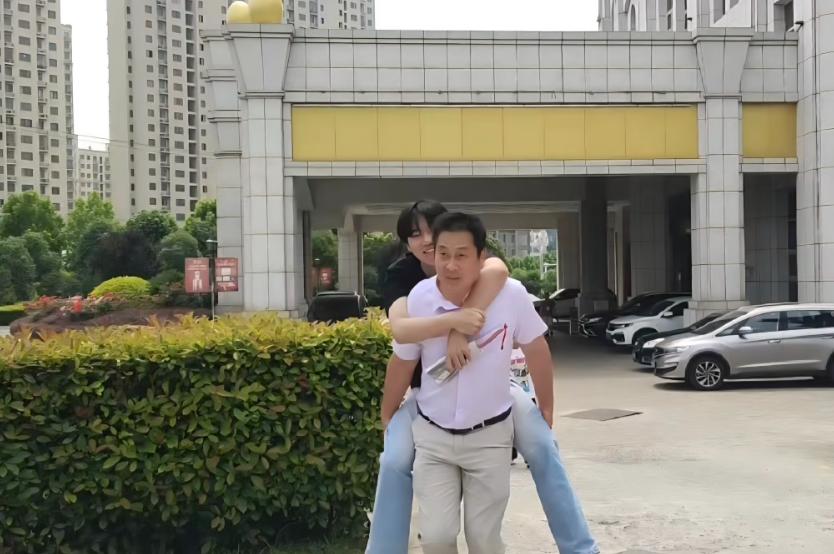 53岁，一米六几的个子，背着比自己高一头的、一百六七十斤的学生，一步一步往前走。