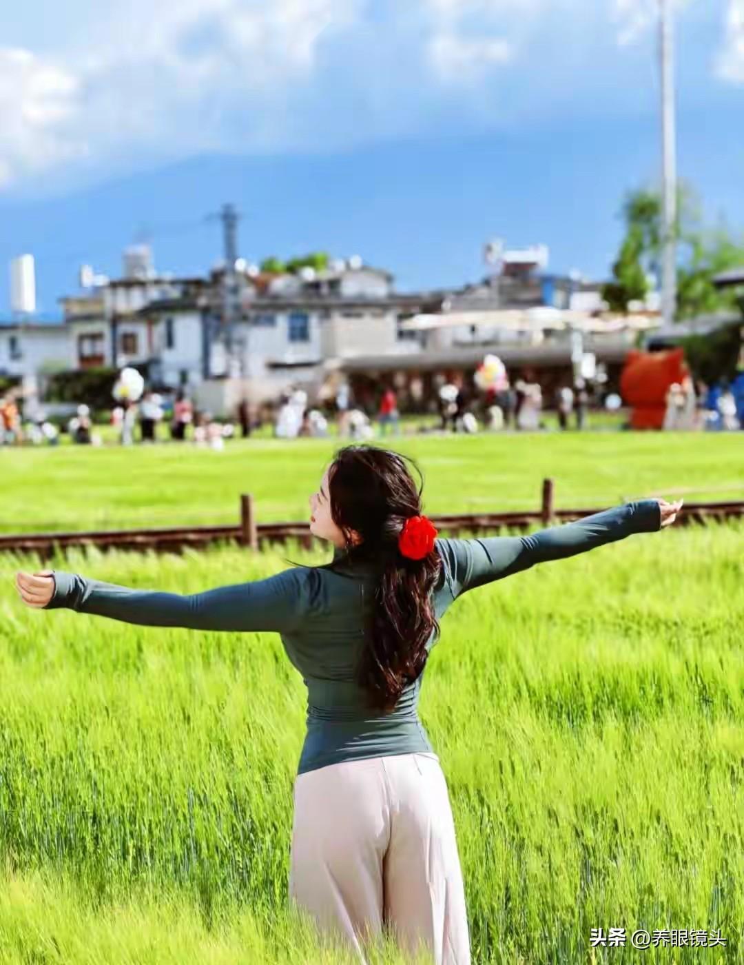 阳光明媚，女孩在田野里张开双臂。