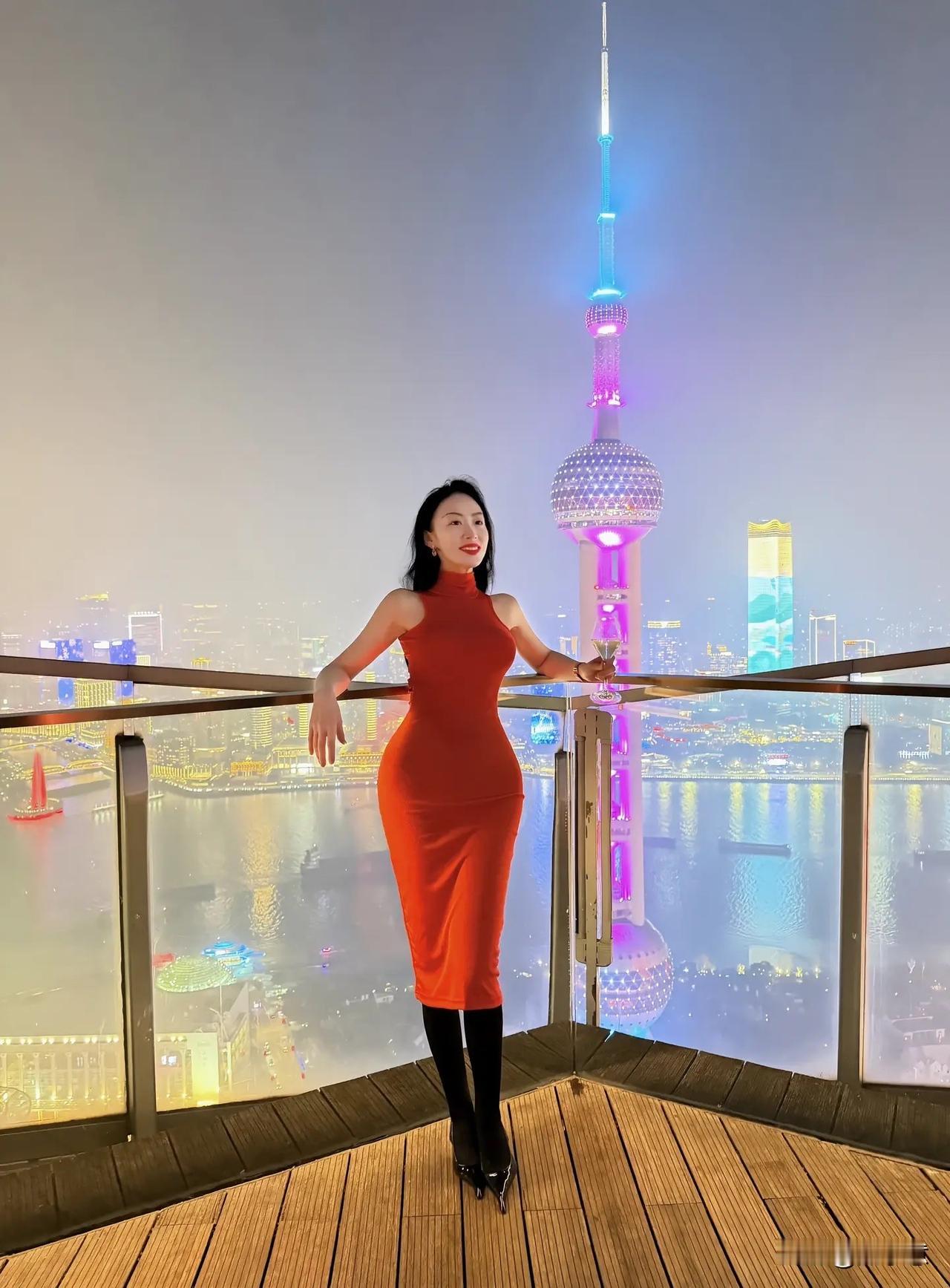 夜晚上海外滩，东方明珠塔下，红裙女子与城市夜景相映成趣。