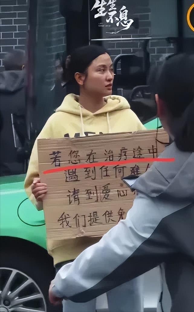 四川成都，华西医院门口有一个女孩子胸前举着一块牌子，写着提供免费住宿吃饭，很多人