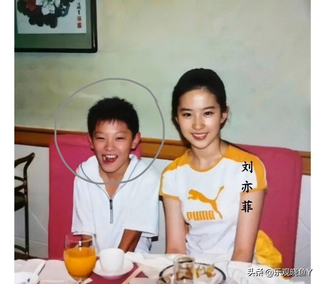 这张照片记录下了刘亦菲与一个小男孩在2003年餐桌上的美好瞬间，那时候刘亦菲十六