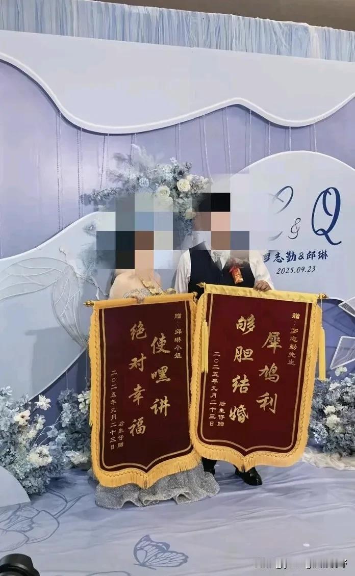 网上有句话，叫做粤语果然可以为所欲为。一对新人拿着一对锦旗面向台下的嘉宾展示着。
