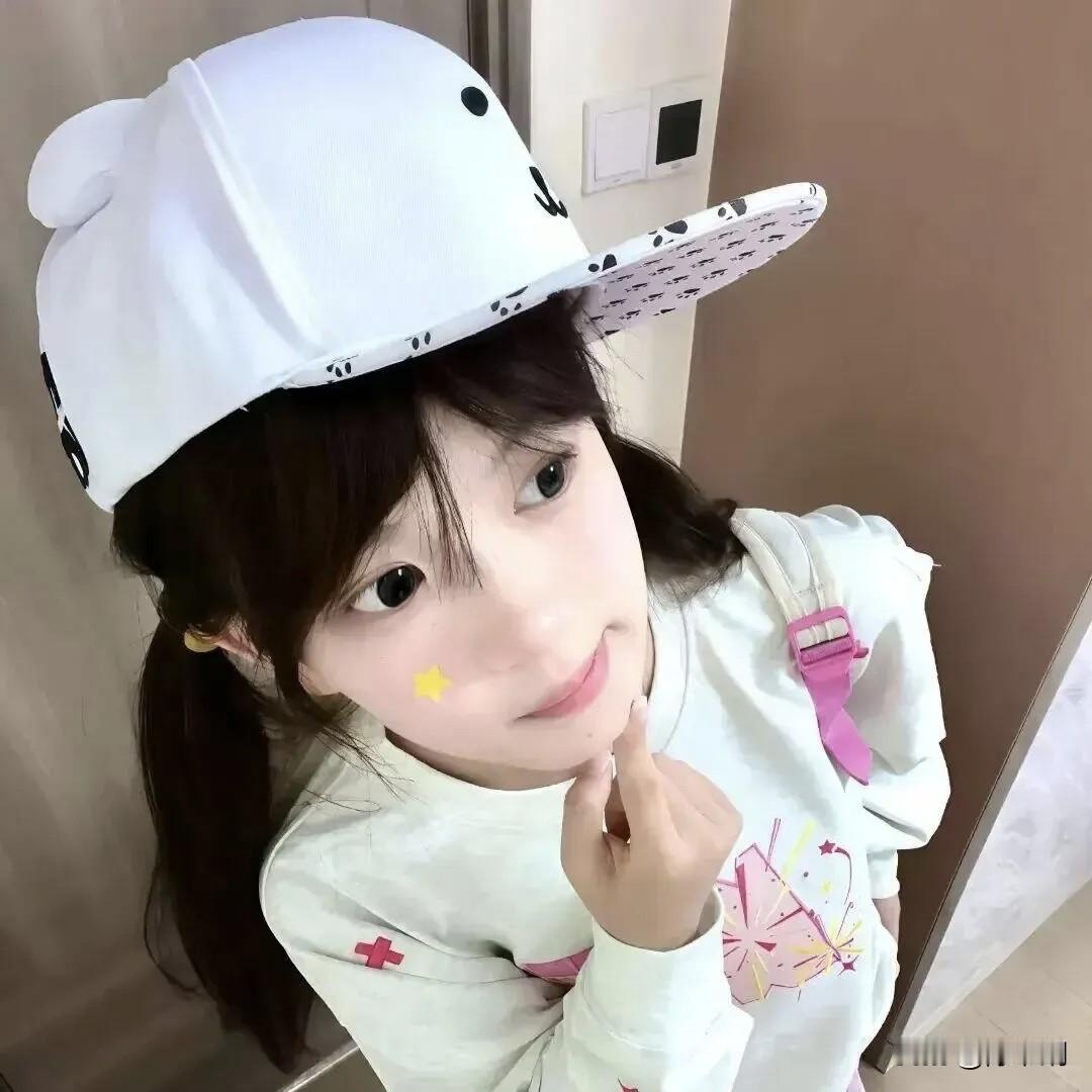 白帽轻扬缀墨斑，双鬟垂缕鬓云弯。
星黄一点腮边缀，指捻芳唇意未阑。
眼波流转凝秋