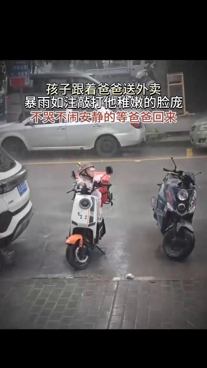 孩子跟着爸爸送外卖，暴雨如注敲打他稚嫩的脸庞，不哭不闹安静的等爸爸回来。爸爸送完