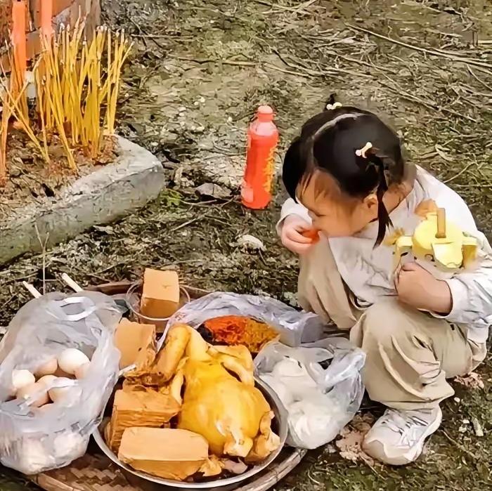 扫墓现场祭品刚摆好，广东一小姑娘竟然当众“开席”了！这胆子也太大了，难道不怕老祖