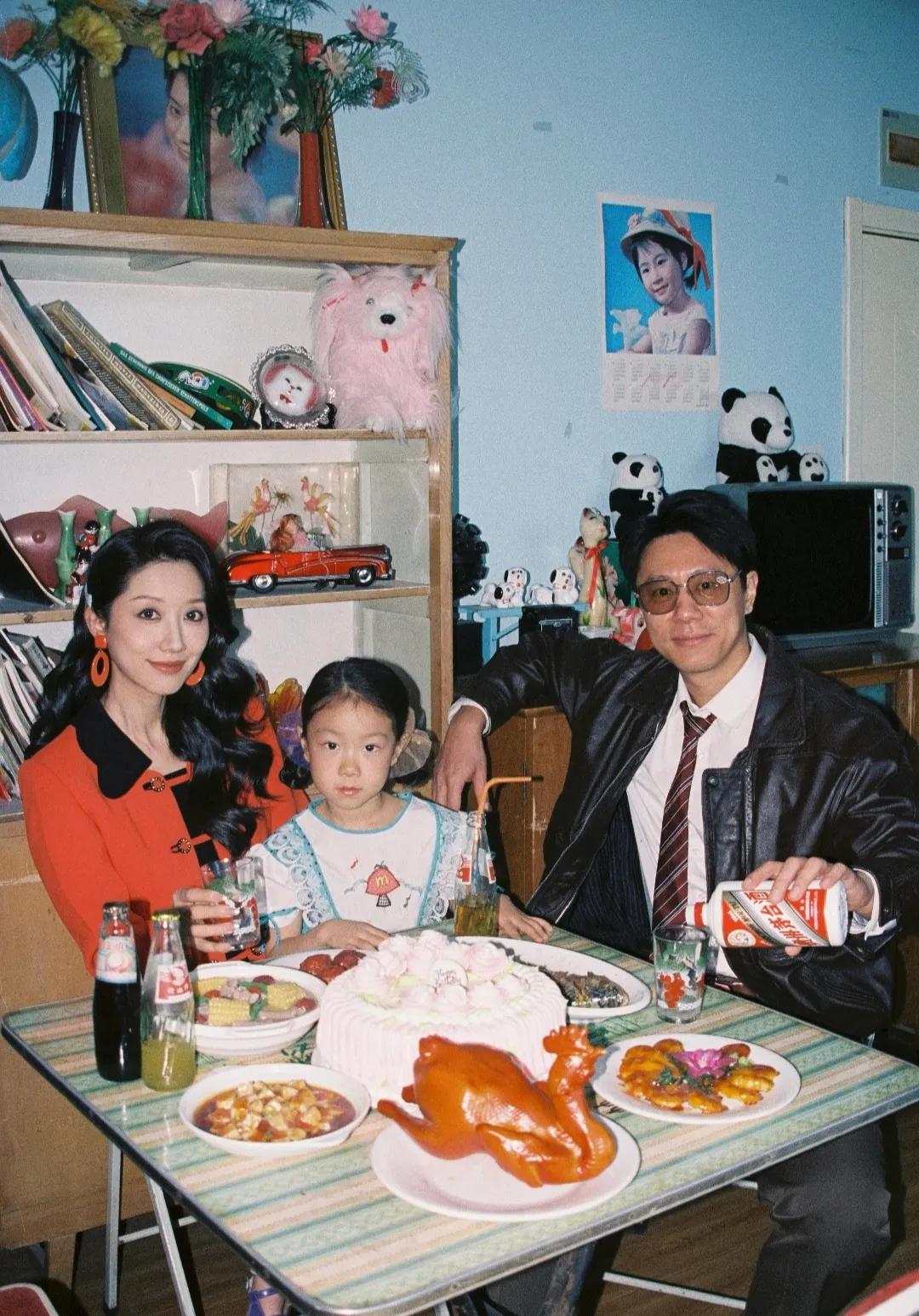 穿越到90年代的家庭照，老折叠桌、绿冰箱、沙发上的蕾丝罩还有粉色毛绒玩具都是那个