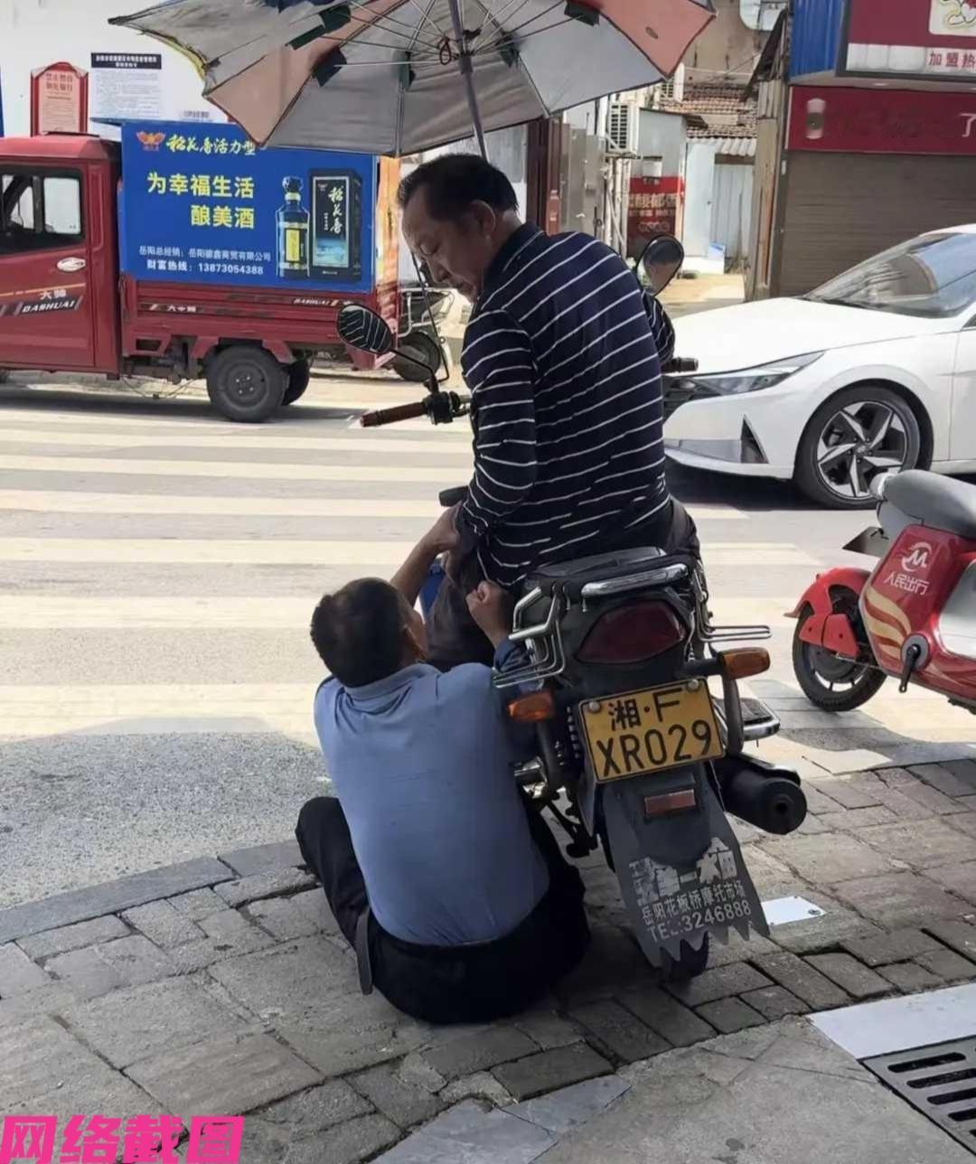 有看到某个老人躺在地上，还用手抓着他人的摩托车轮不松手，且这时的车主也不和老人对