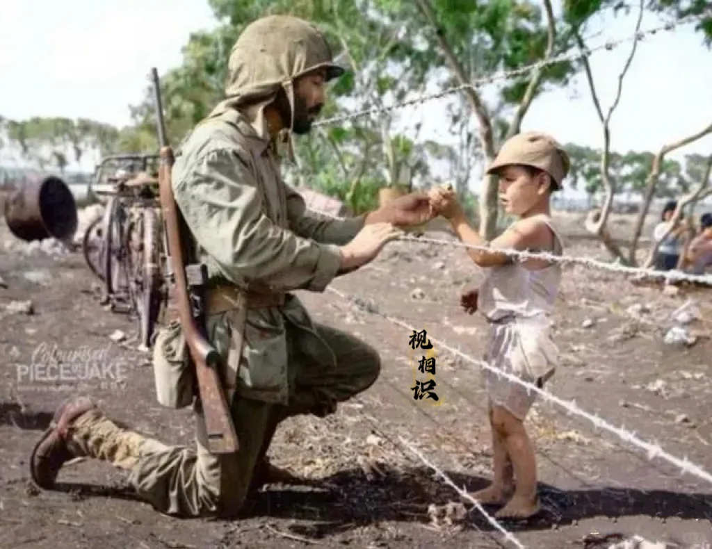 1944 年，天宁岛战役时期，美军第四师的费德里科·克拉中士，正单膝下跪，给铁丝...