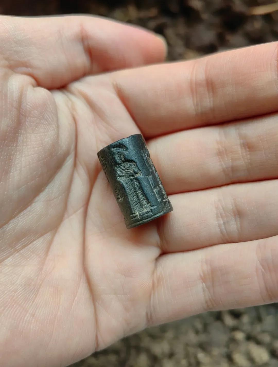 清鱼塘时挖出来一块黑石头，表面刻着几个模糊的人像，轮廓看起来还有点像外国人，石身