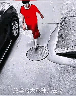 这才是中国大妈该有的形象。
马路上，着红色衣裙的大妈一脚踏上松动的窨井盖，差点掉