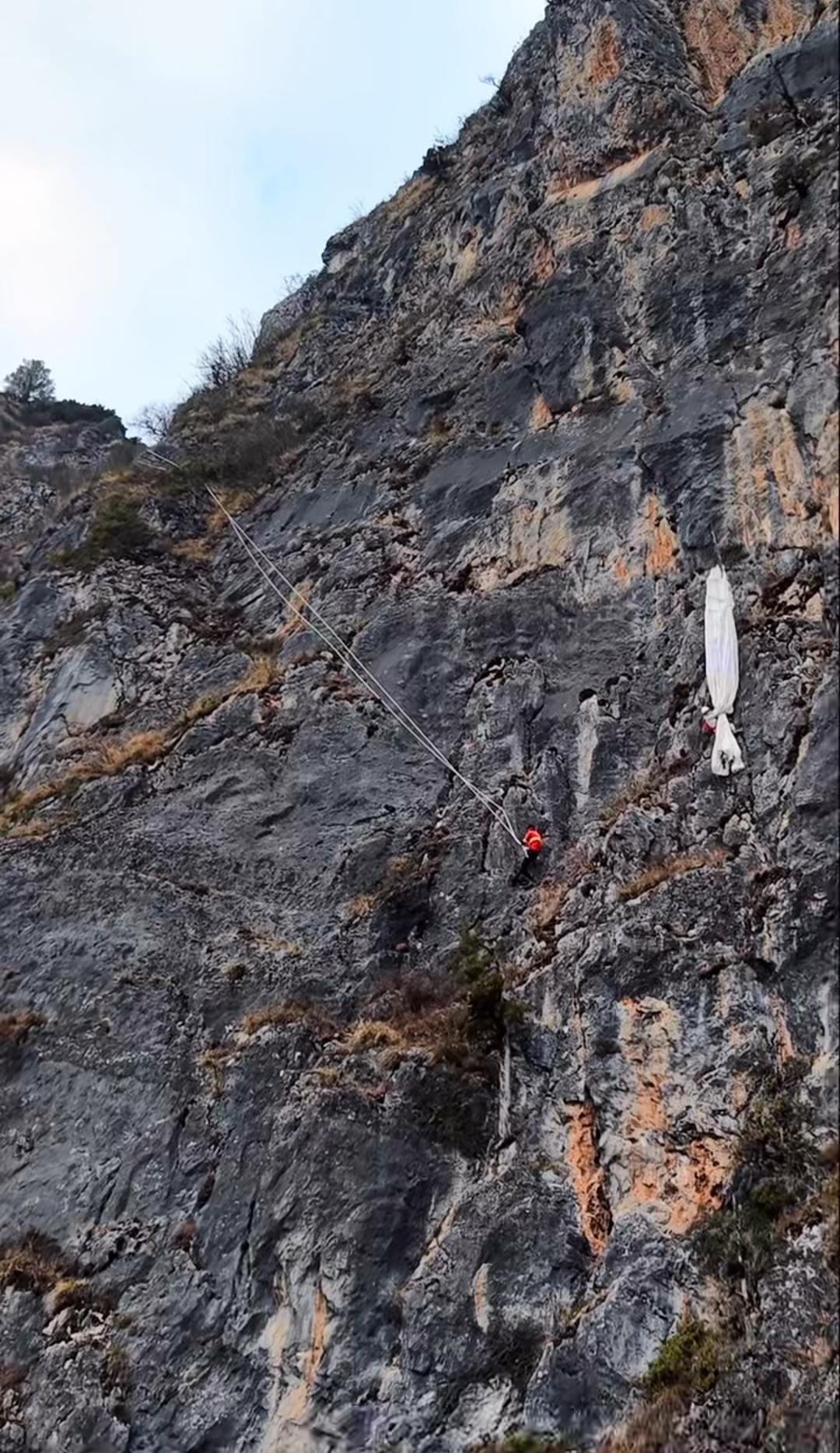 女子跳伞时意外挂在150米高的悬崖上，悬空5个小时！崖下的舅舅看着头顶的女儿，血