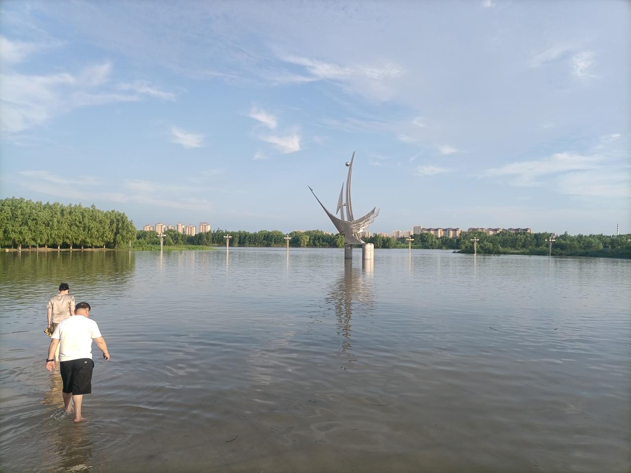 【公园涨水即景】
 

  辽澜漫入游园场，
  鹤塑亭亭碧水央。
  浅岸游人