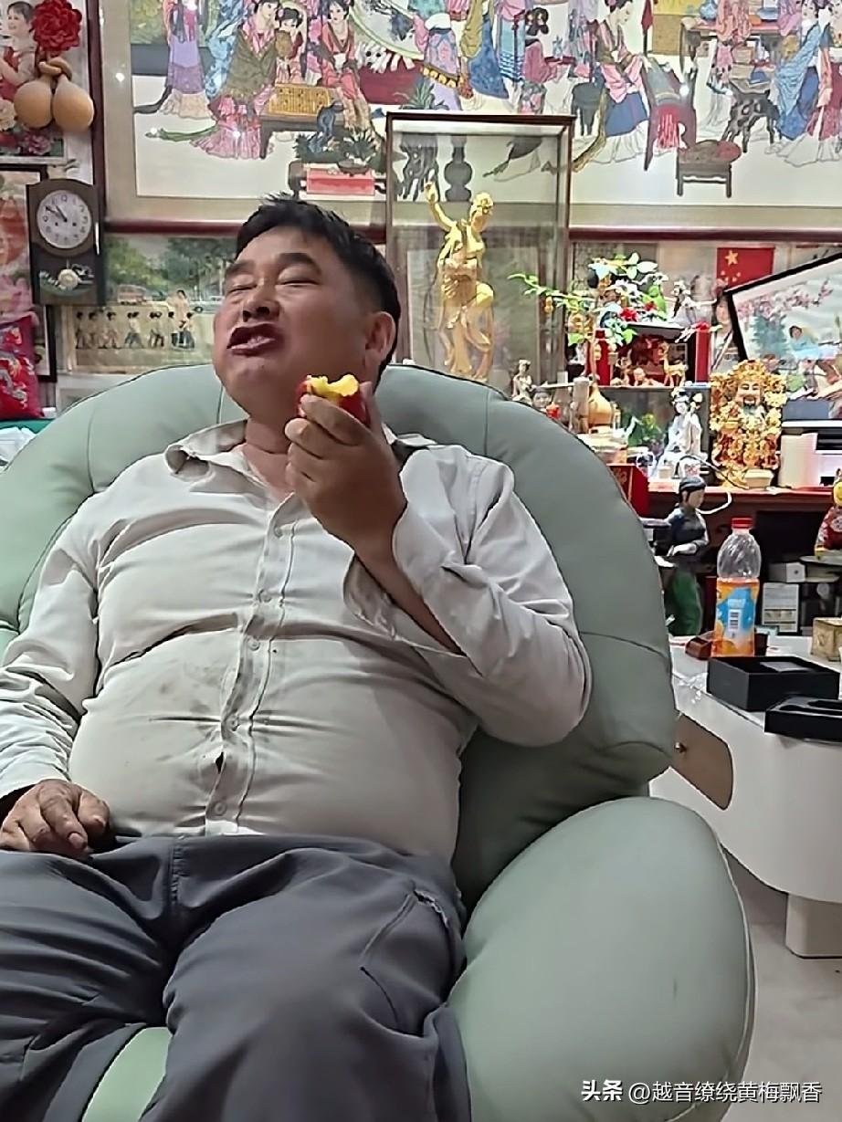 朱之文惬意地坐在沙发上吃着桃子，嘴里念叨着红红火火、走亲访友，还直说这桃子好吃，