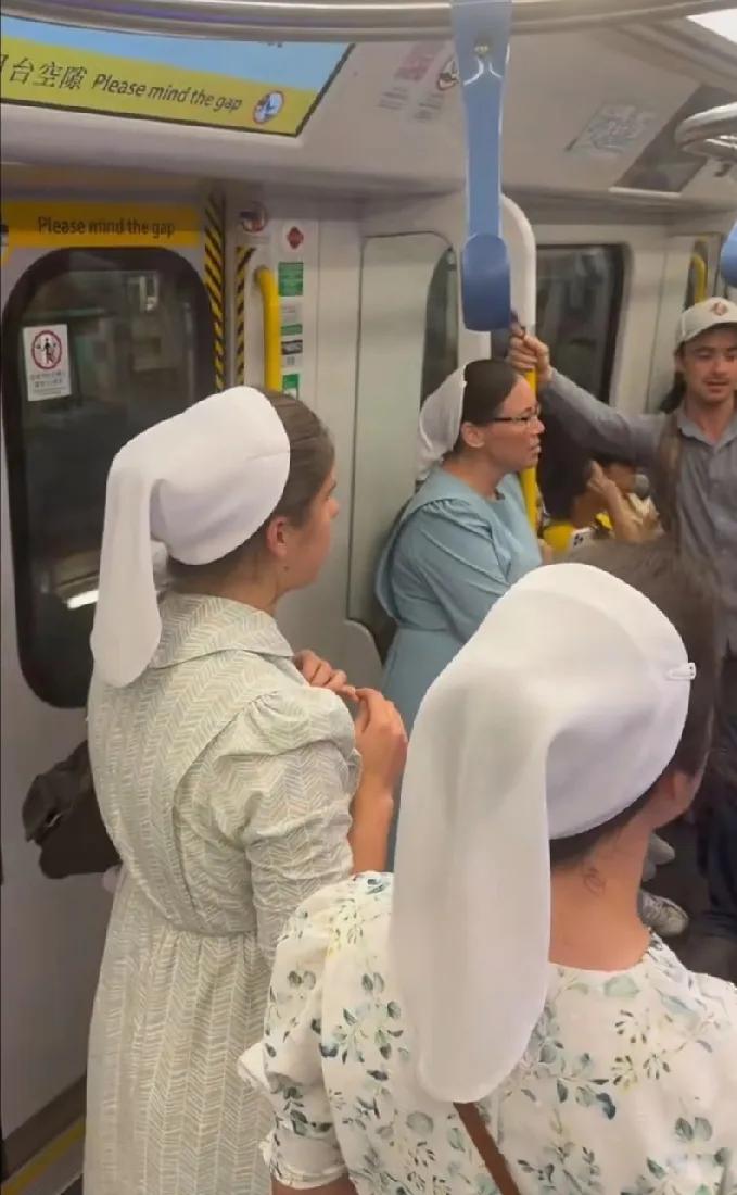 一群戴白头巾的外国人在香港地铁大声唱歌，热情好客的香港人安静欣赏，没有人觉得吵闹