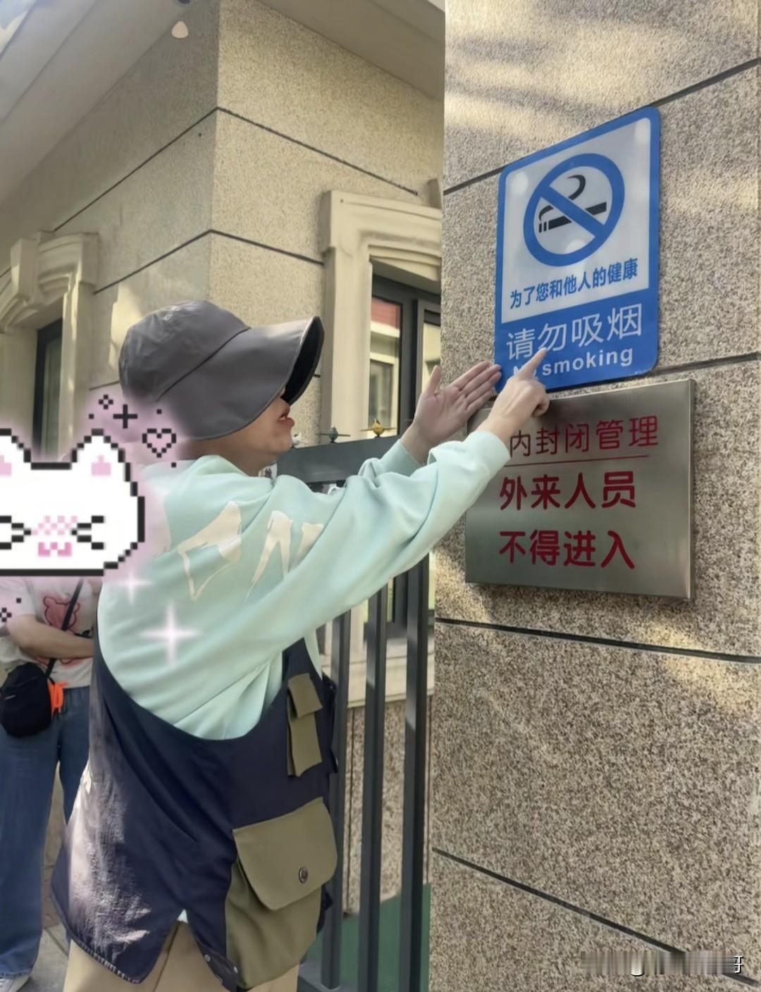 这是我最近看到宣传禁烟算是比较正常的一个人，幼儿园门口贴有禁烟标识，该女子看到一