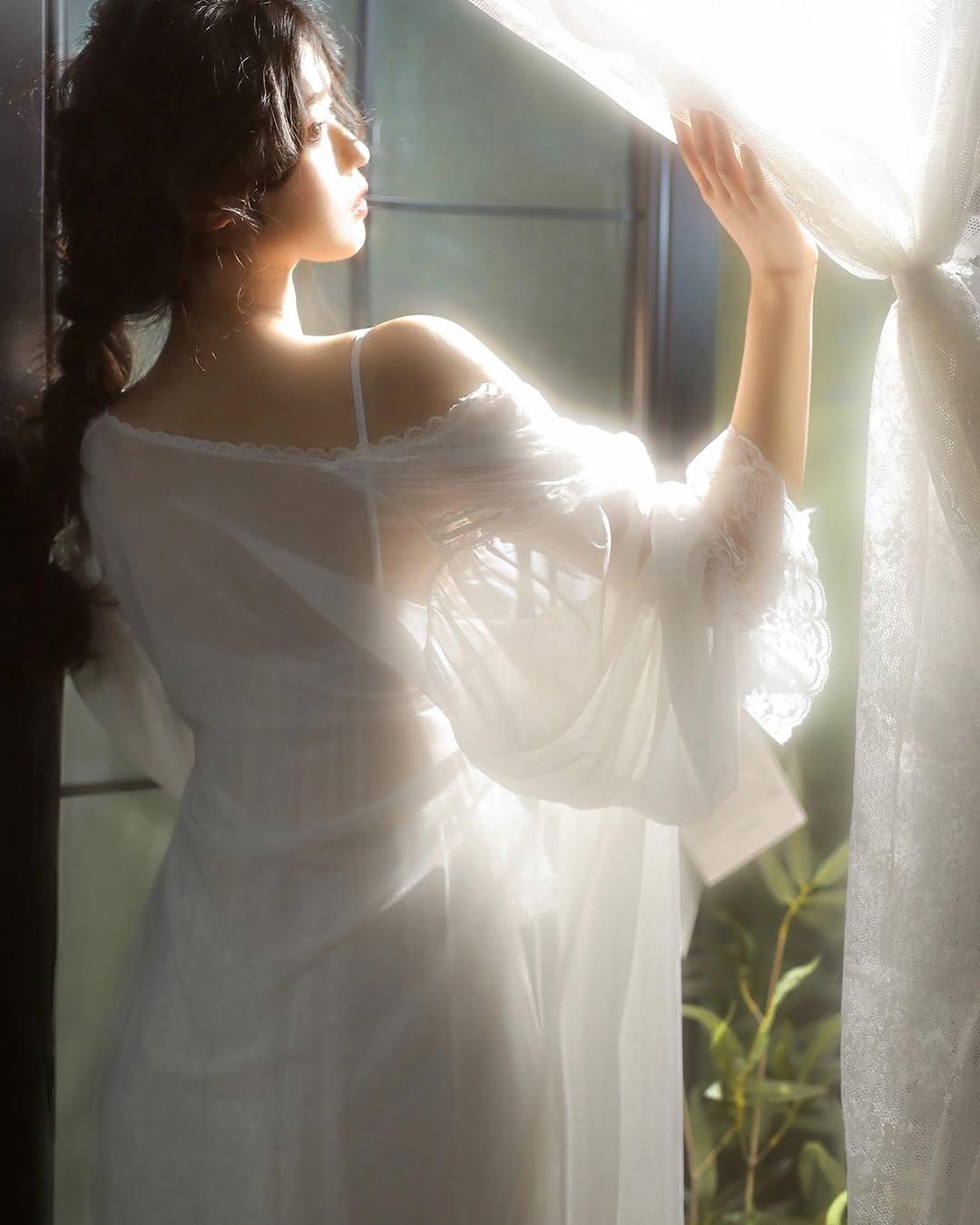 阳光透过窗帘，照亮了她的侧脸。