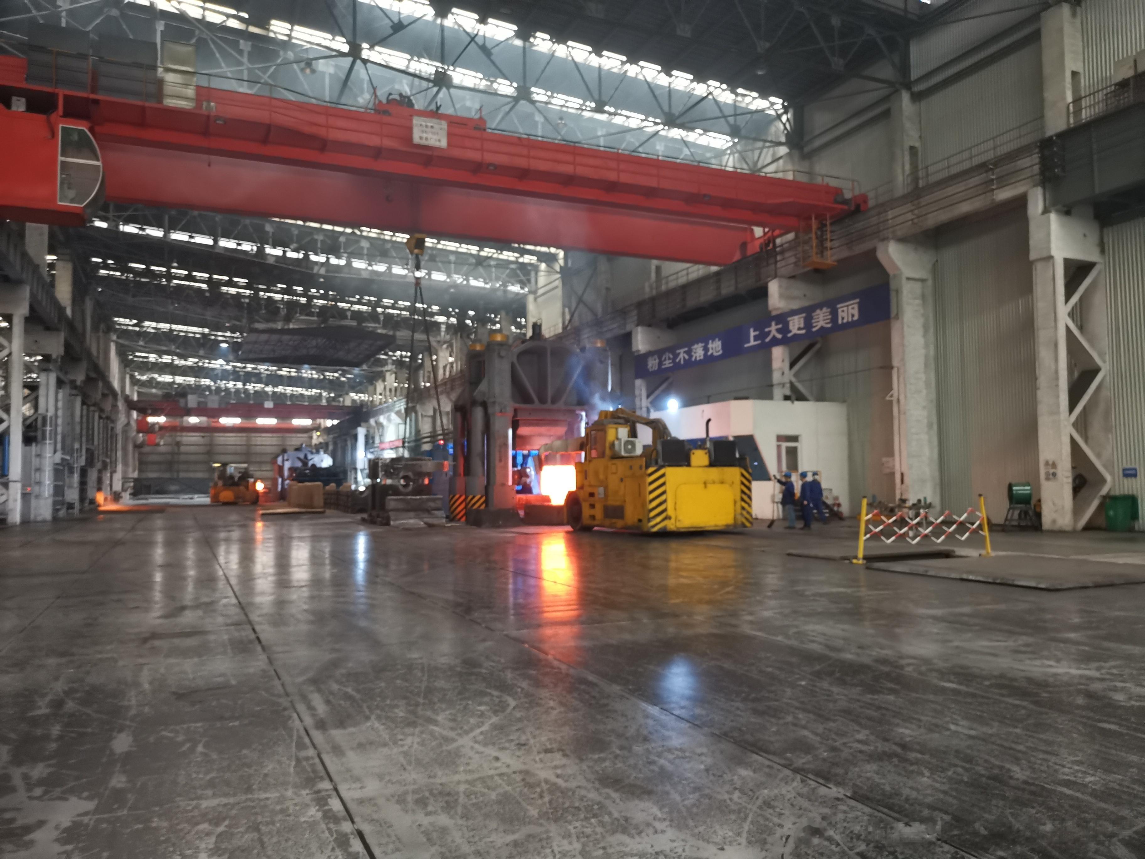中航上大车间内6000吨锻机正在特种作业车加持下忙碌，滚烫的热浪扑面而来——这里