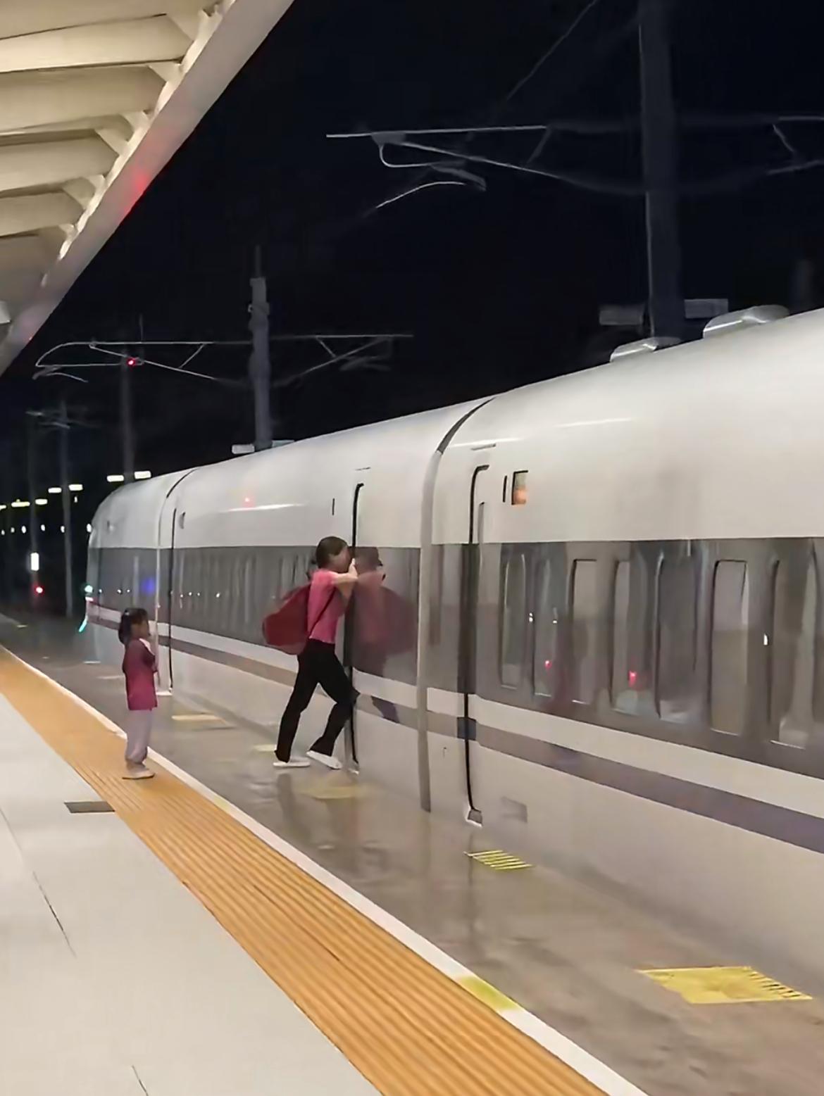 广东阳江站，一名女子扒车门阻挡列车出行，原因是她有一个孩子没下车，站方回应批评教