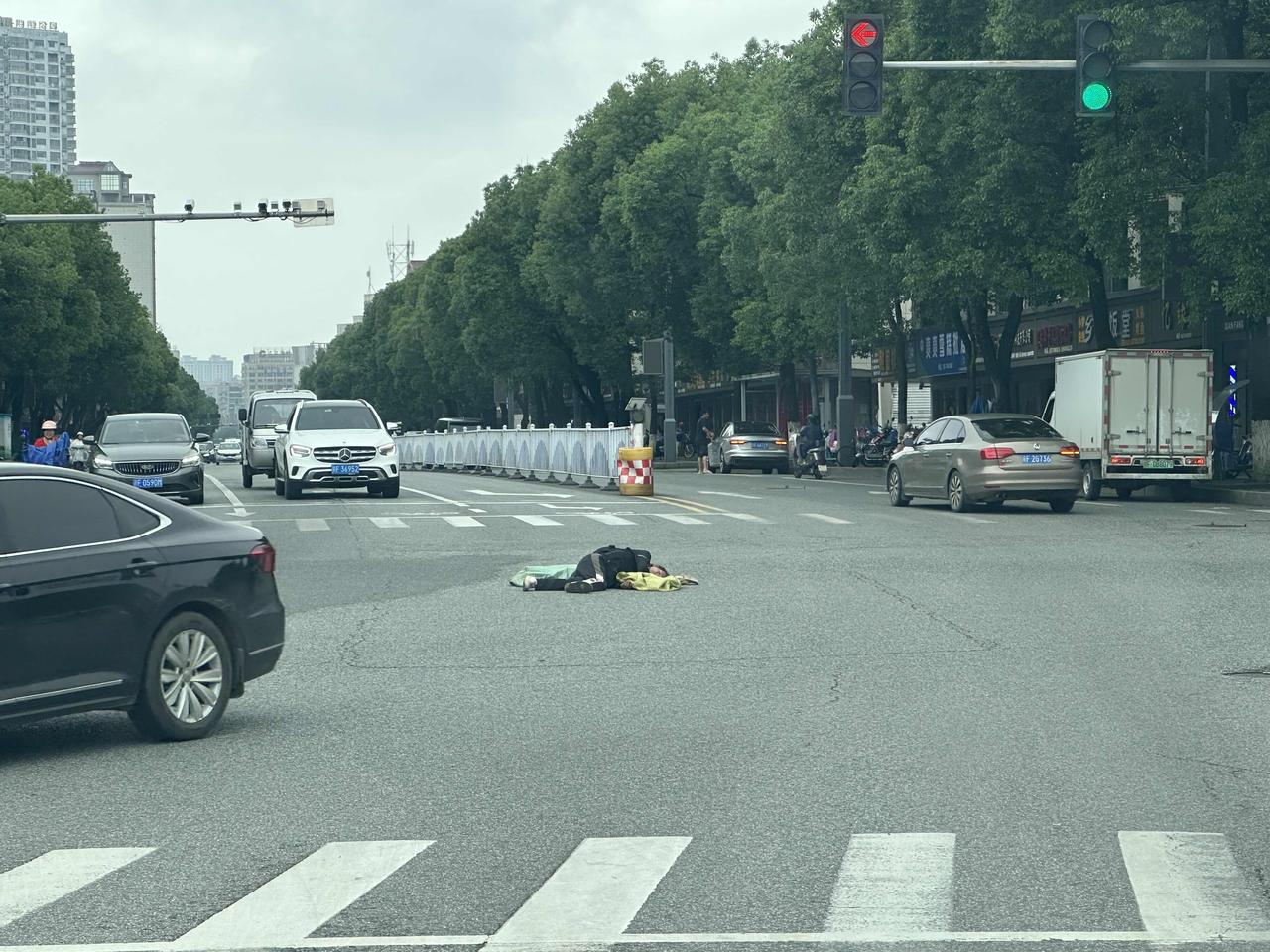 今天开车路过十字街头，眼前的一幕让我心里久久无法平静。车流穿梭的马路中央，我亲眼