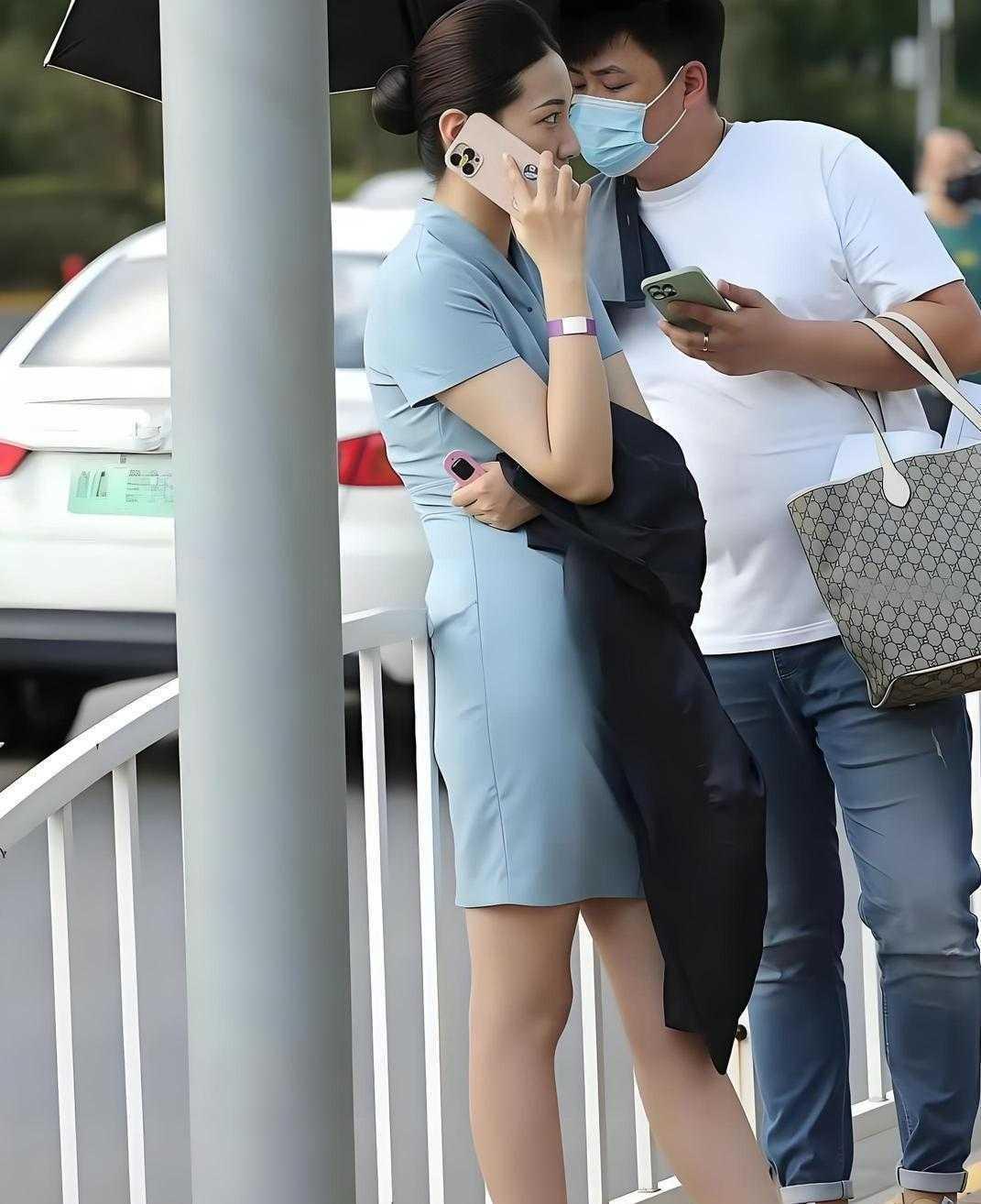 一身浅蓝色的修身连衣裙，利落干练的盘发，淡淡的妆容，端庄优雅，职业气质拉满，应该