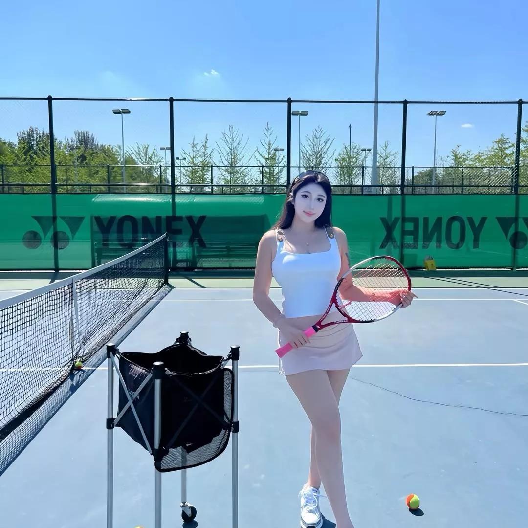 阳光明媚的网球场上，美丽的小仙女手持网球拍，微笑拍照。