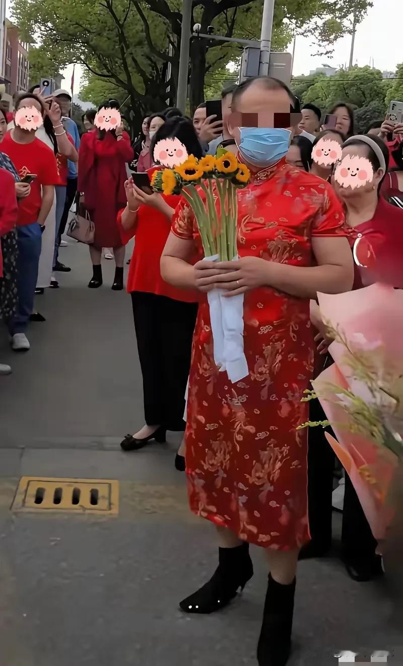 有这样的父亲，孩子能好好高考吗？
照片中这个男家长，女扮男装，穿红旗袍高跟鞋，拿