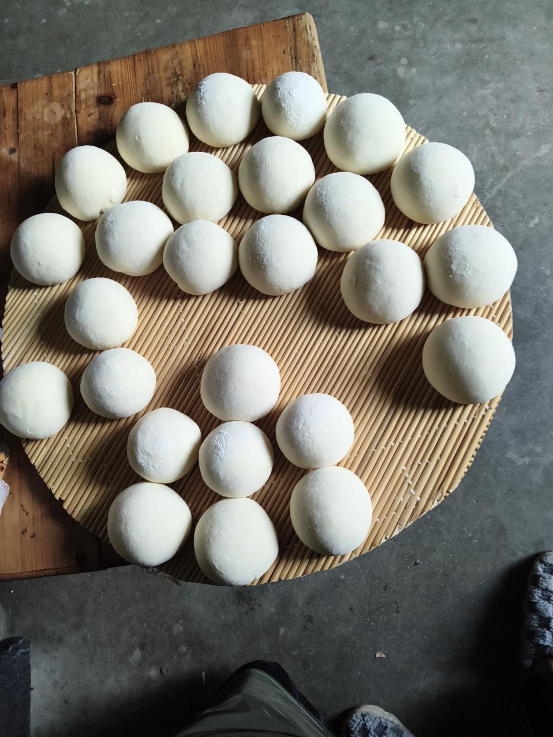 竹簸箕上，二十多个浑圆的面团列队静候，是北方年节最朴素的仪式。每一个都匀称饱满，