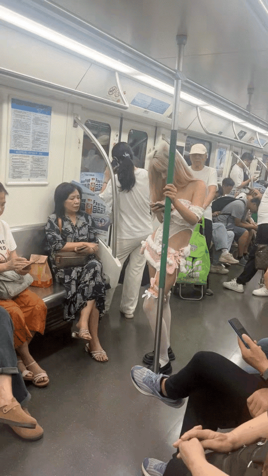 上海地铁，一位妙龄女子的衣着引起了关注，特别是一位大妈，有些目瞪口呆。女孩金发披