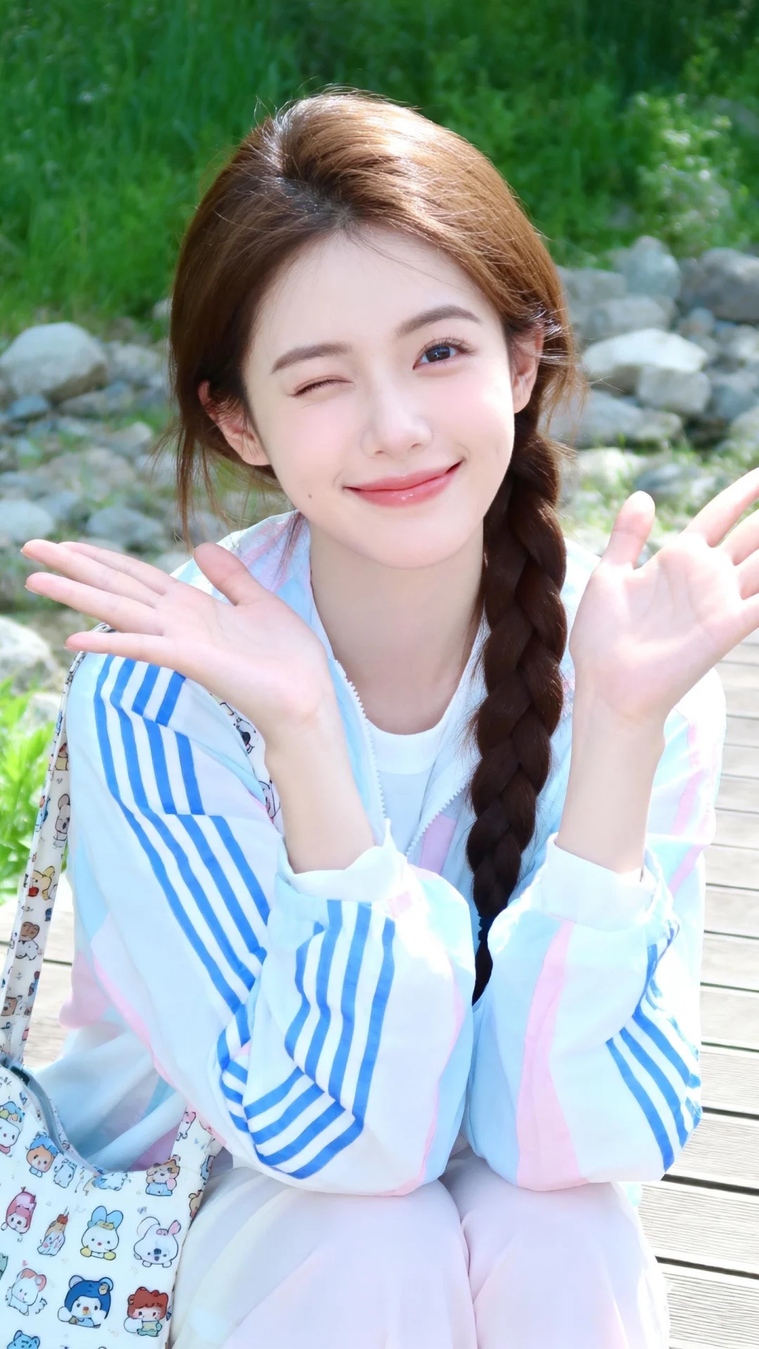 这是一张相机拍摄的照片场景选在户外自然区域背景是绿植、石块与木质平台...