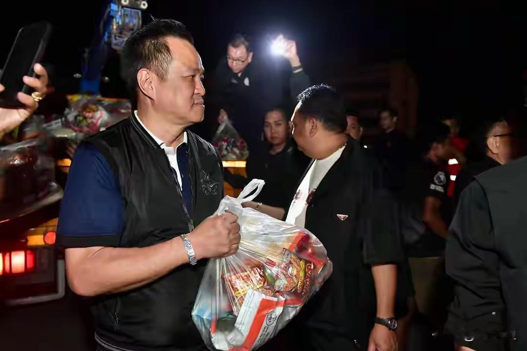 阿努廷这个总理挺忙的，又是拎着食物又是扛着水，还和士兵聊得专心。