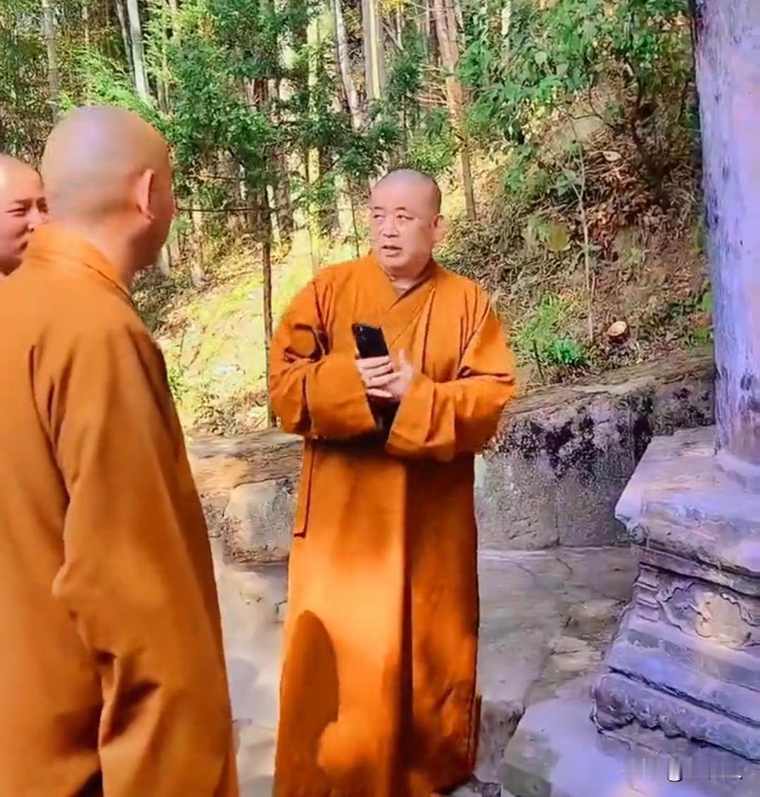 释永信手持手机，正和身旁其他僧人交谈。安徽天柱山三祖寺山间步道，释永信到访外地古