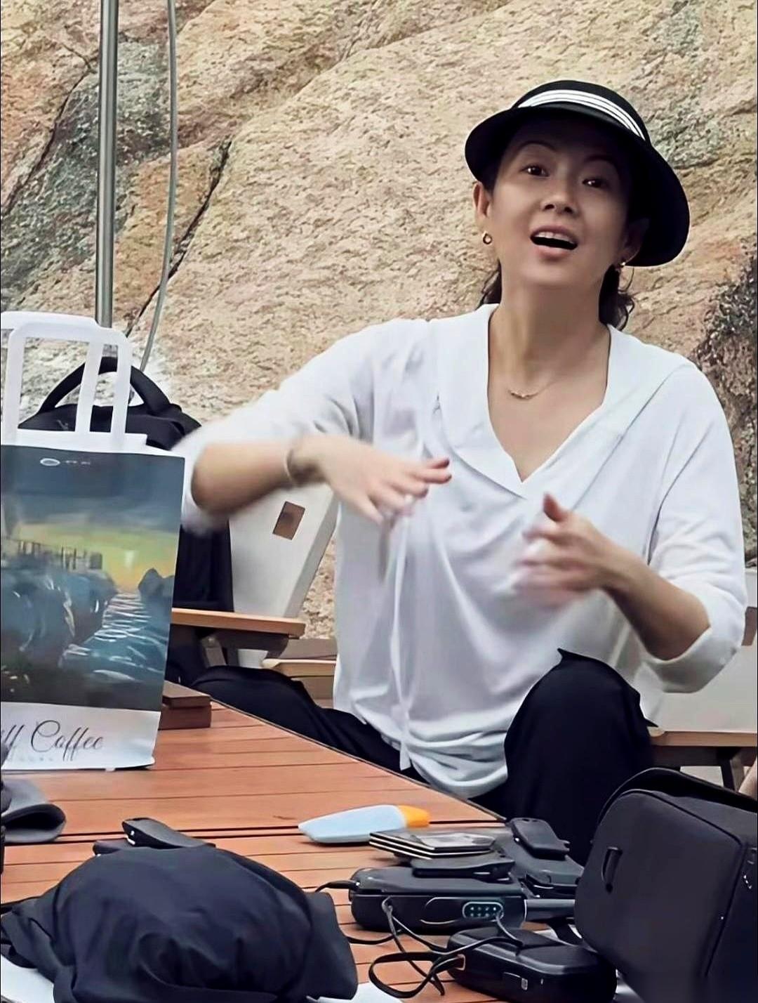 这张章子怡的照片，真得看两遍。
第一眼，就是一个普普通通的女人，在路边站着。宽松