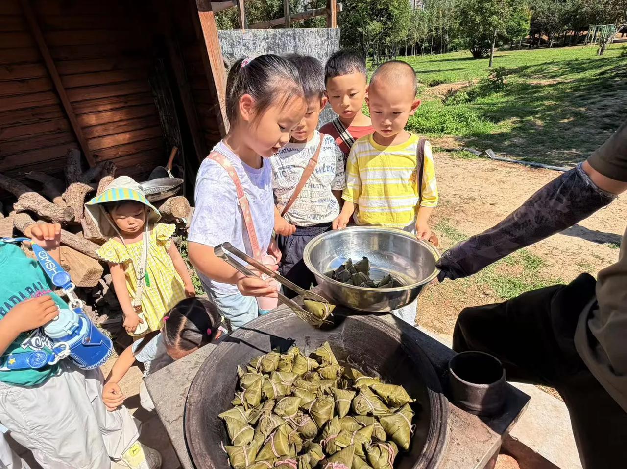 端午前夕，幼儿园后厨的大铁锅咕嘟咕嘟冒着热气，满满一锅粽子终于熟透了。粽叶的清香