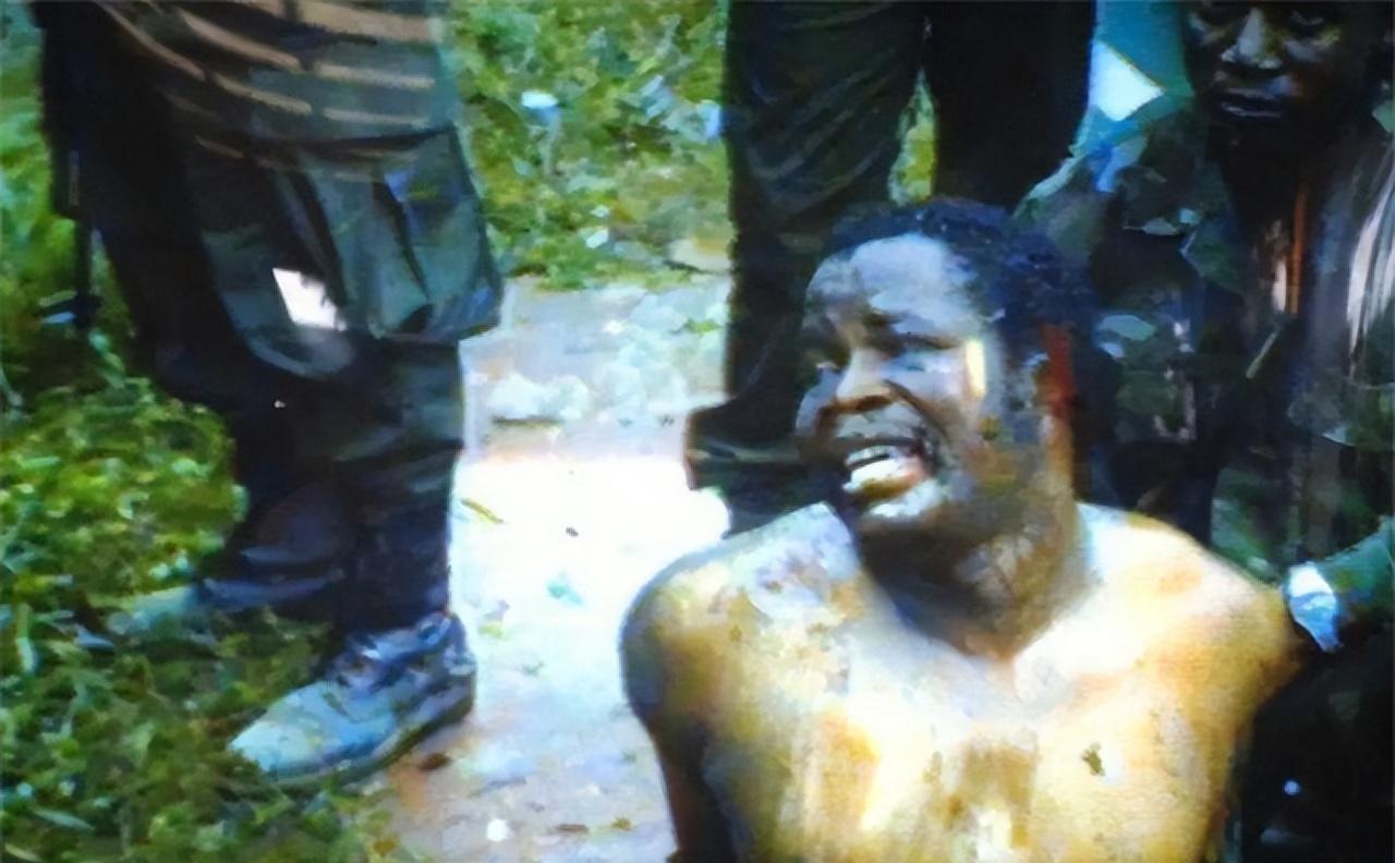 这是1990年，利比里亚土著人总统多伊赤裸着上身瘫坐在地上，浑浊的眼睛望着周围冷