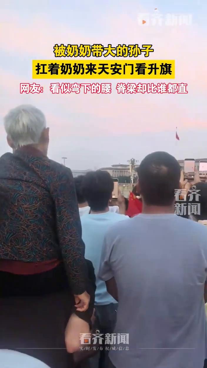 被奶奶带大的孙子扛着奶奶来天安门看升旗。
看齐新闻。
网友：看似弯下的腰脊梁却比