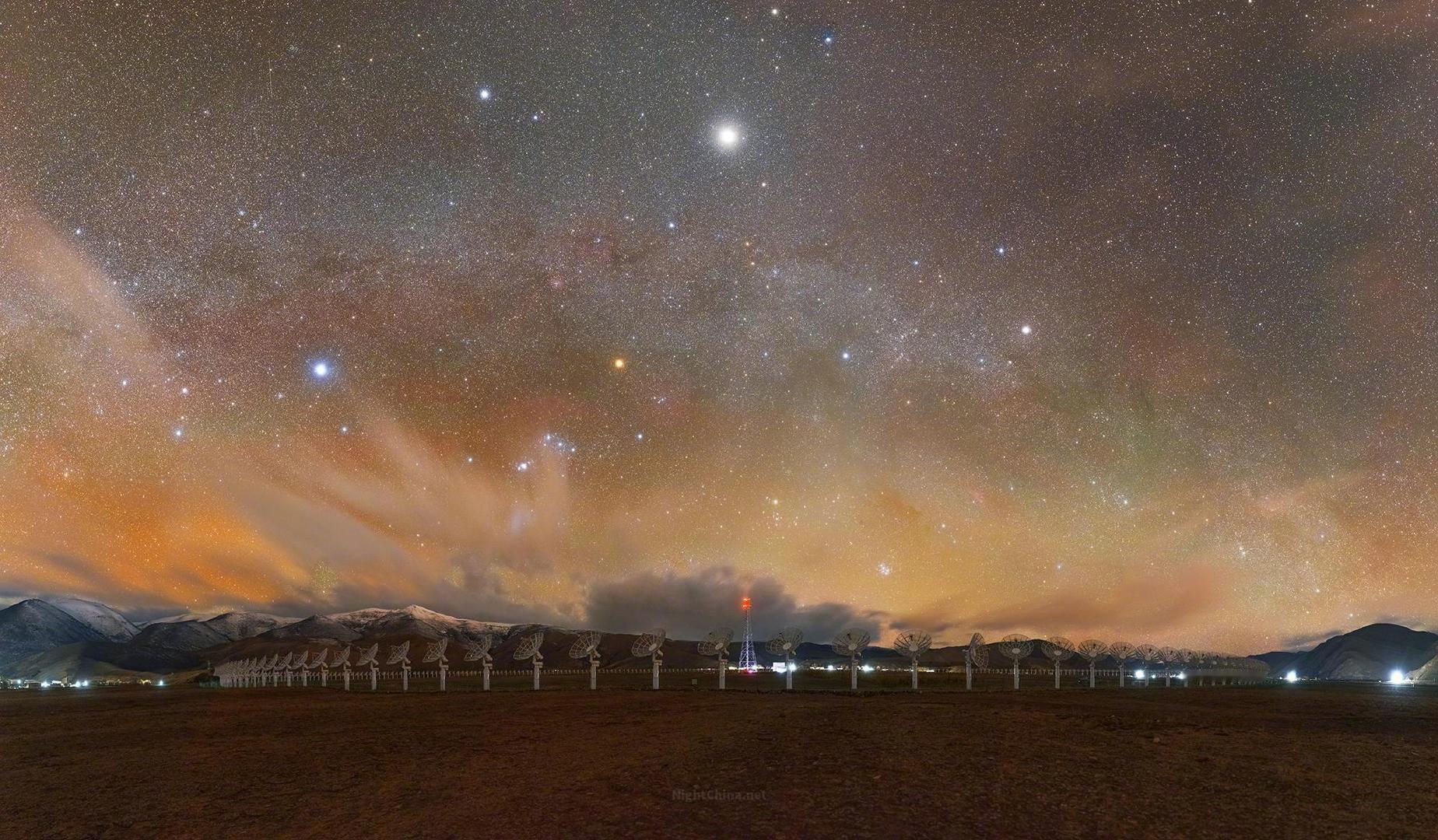 当橙色气辉与银河的微光在夜空中悄然相遇，旷野便有了某种难以言说的辽阔。雪山横卧天