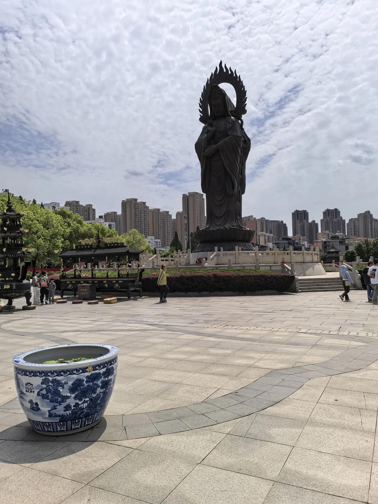 澄澈蓬松的云天铺满整片上空，绵软的云朵自在舒展，清风漫过寺院广场。高大庄严的观音