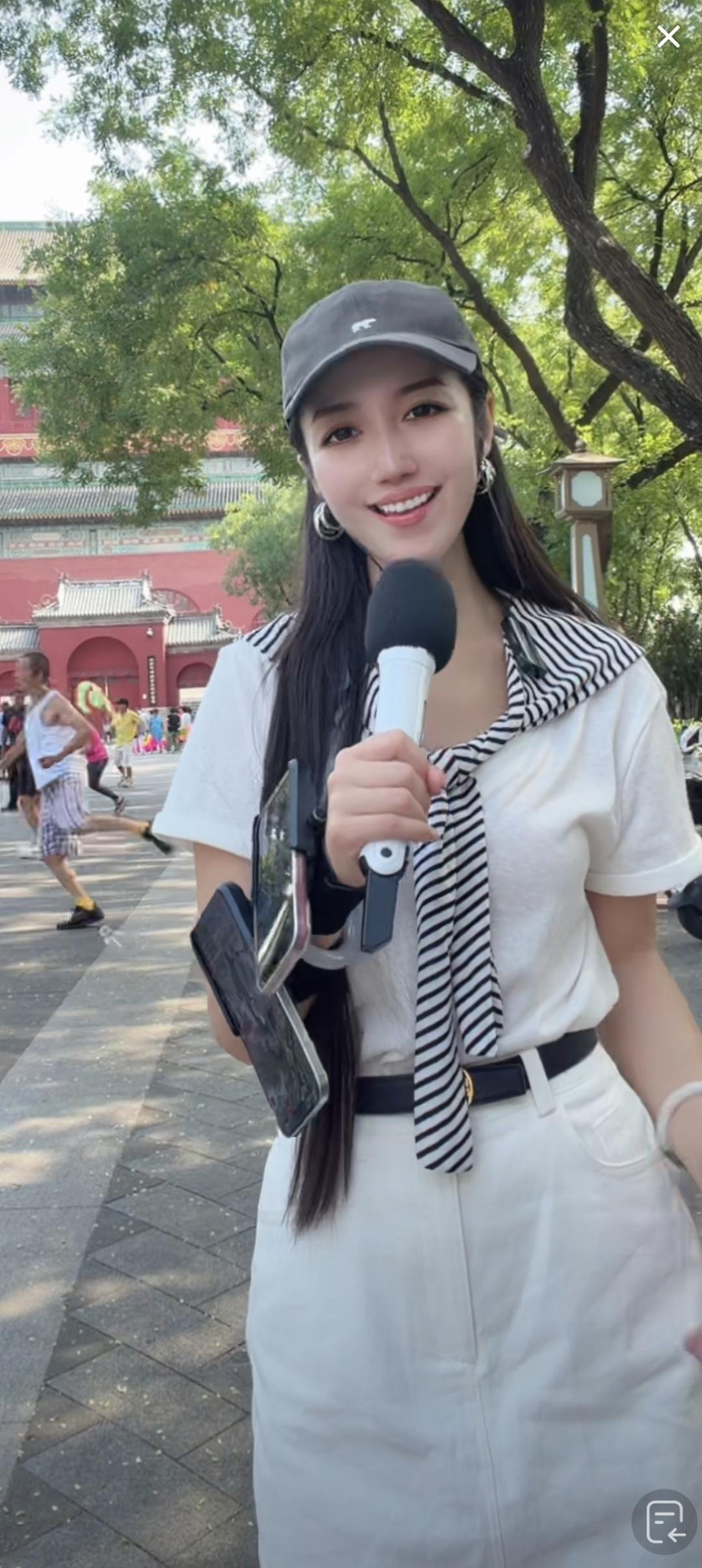 这姑娘拿着话筒在户外直播呢。