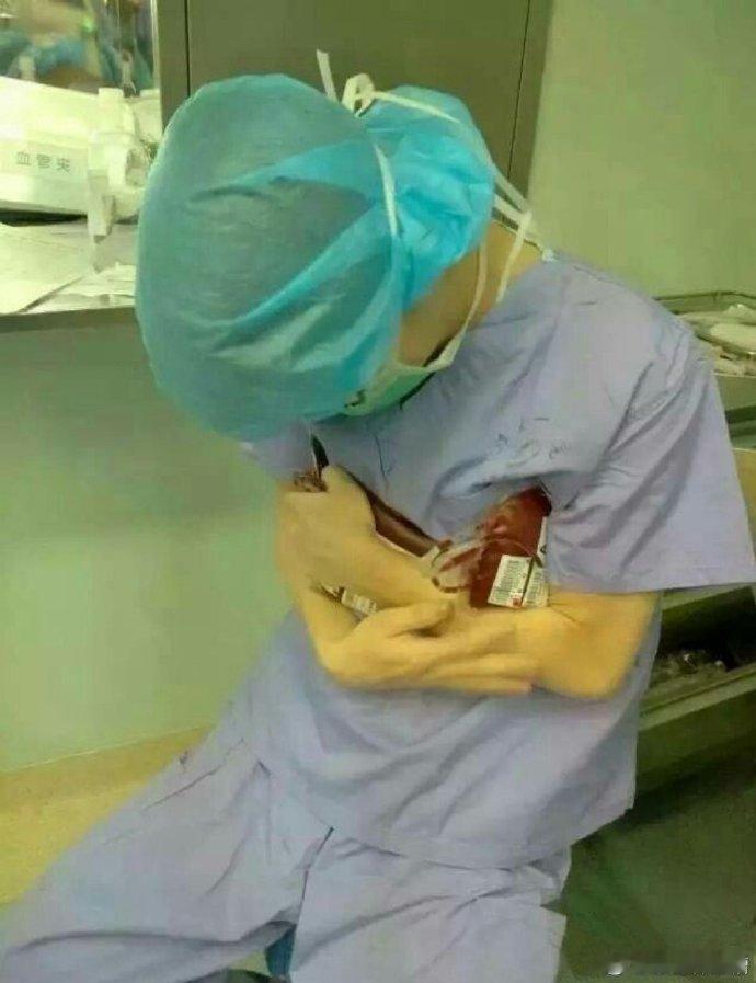 被这张照片深深的感动！医生将冰冷血袋抱怀里：求求你快点升温 。[心]河南一医院感