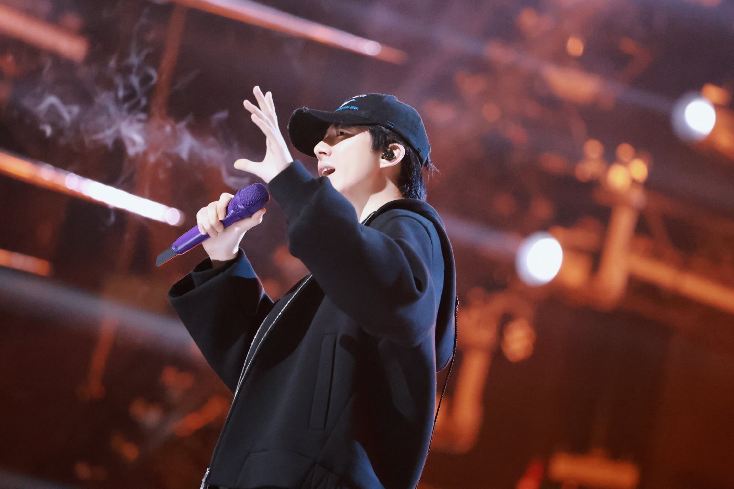 帽檐下的眉眼藏着认真，麦克风握在掌心是底气，从彩排间到舞台中央，一步一步，把热爱