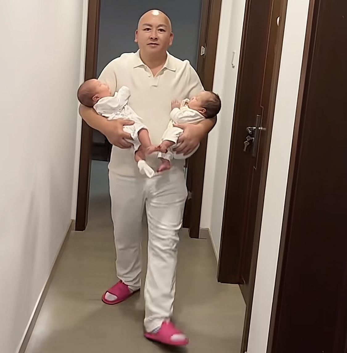 抱着双胞胎女儿的老大爷