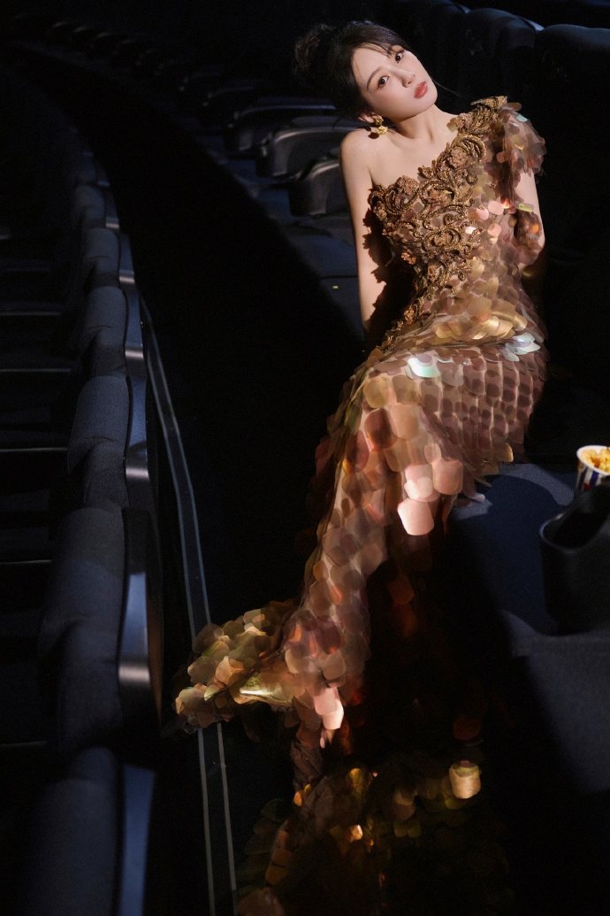 杨紫金色细闪鎏金斜肩裙  杨紫裙摆逶迤牡丹吐蕊  杨紫金色细闪鎏金斜肩裙，是裙摆