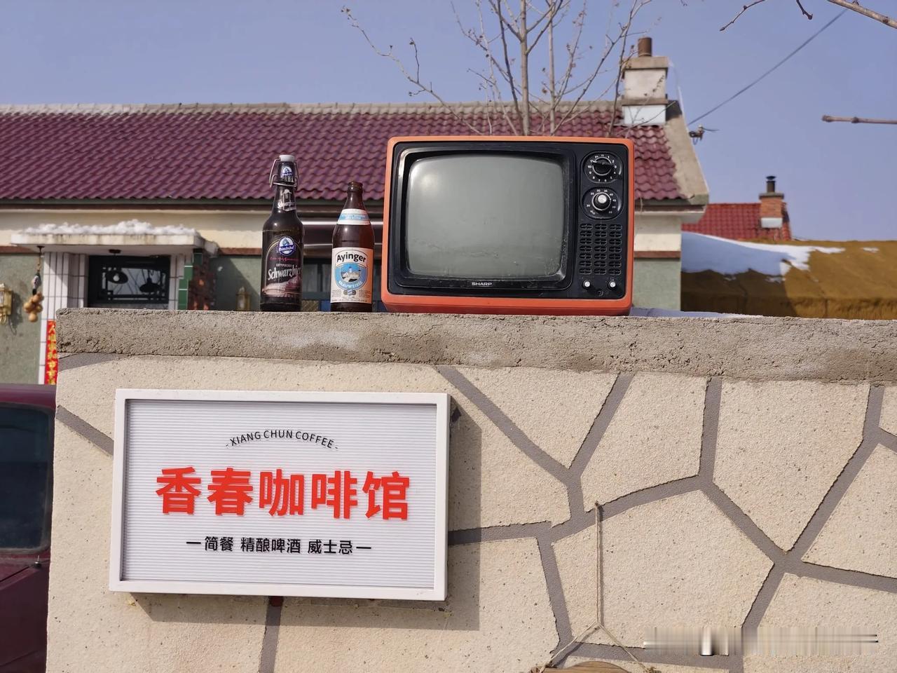 晒图笔记大赛长春友好村有一家咖啡馆，小墙头摆放着老式电视机，两只狗狗路上“招揽客